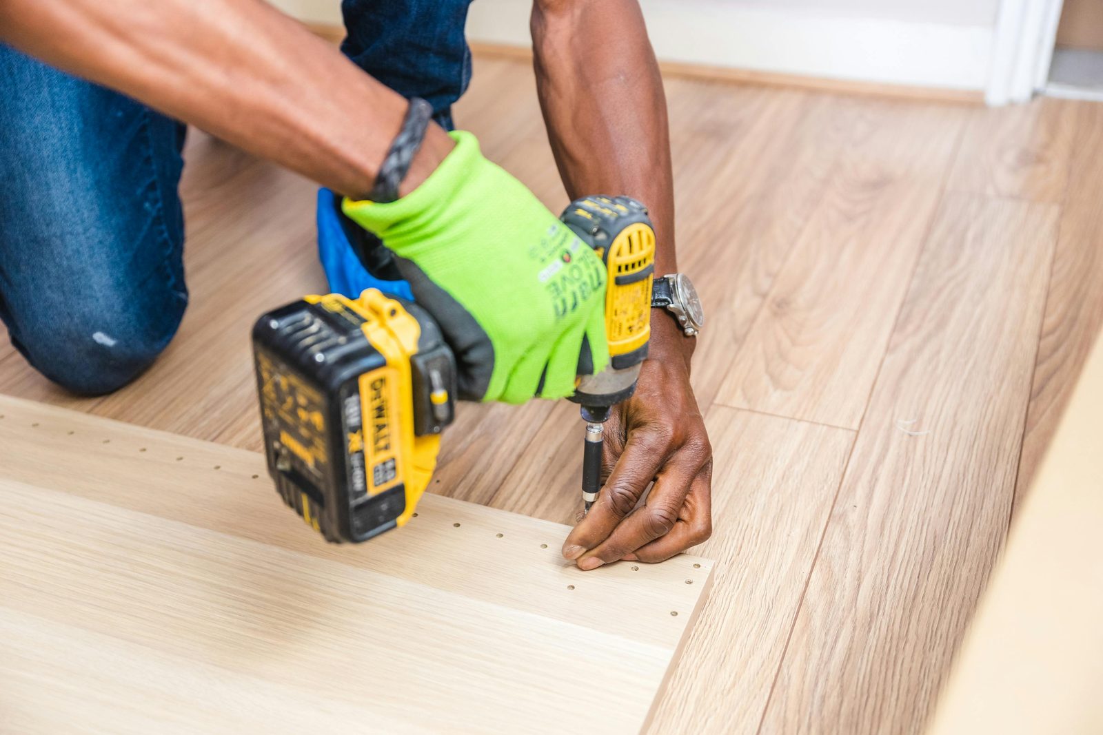 A Great Floors installer fastening hardwood planks