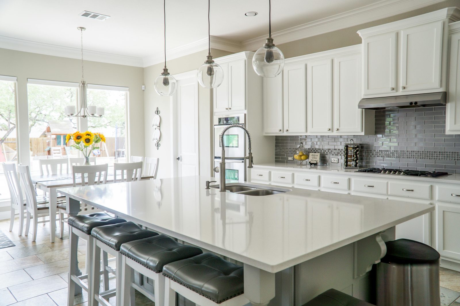 White kitchen with a large island and tile floor