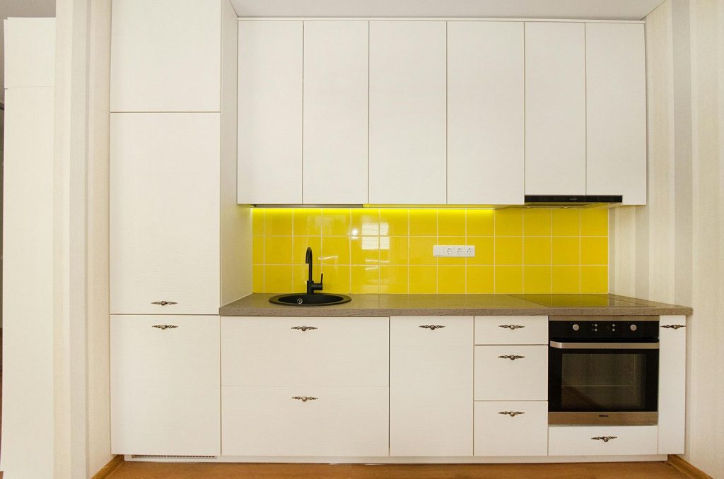 White kitchen with a bright yellow tile backsplash