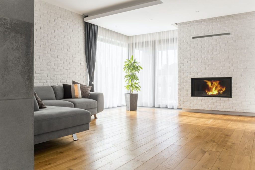Living room with a brick fireplace and wood flooring